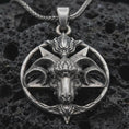 Load image into Gallery viewer, Sterling silver Baphomet goat head pendant necklace with an oxidized finish resting on textured volcanic rock, captured in a close-up premium studio composition.
