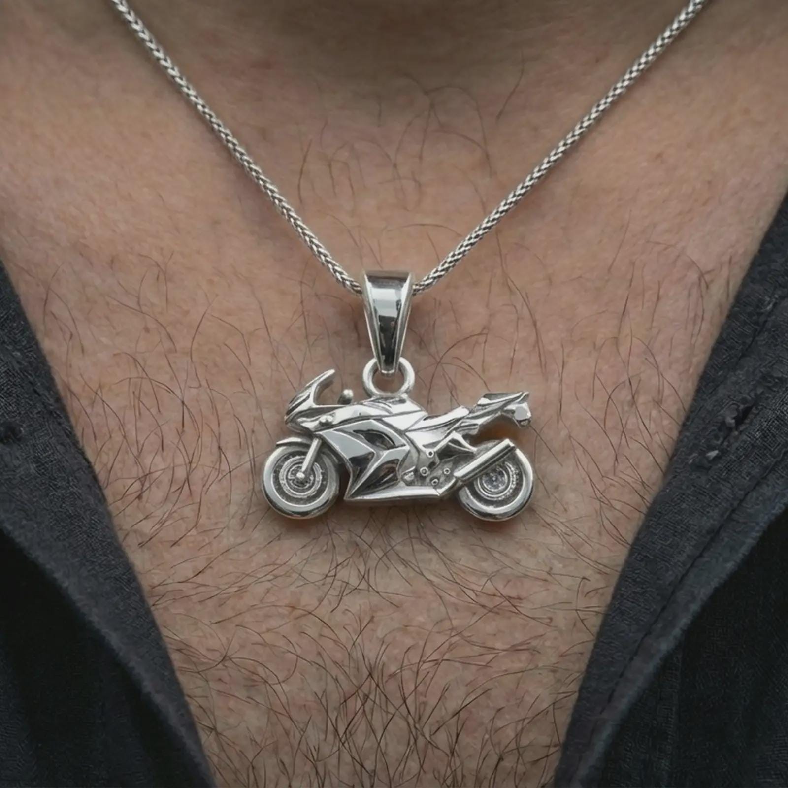 Polished silver sportbike motorcycle pendant necklace worn on the neck, shown against the chest in a clean and dynamic everyday wear composition.