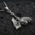 Load image into Gallery viewer, Sterling silver paladin hammer pendant necklace with an oxidized finish resting on textured volcanic rock, captured in a close-up premium studio composition.
