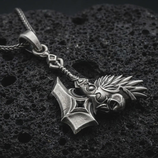 Sterling silver paladin hammer pendant necklace with an oxidized finish resting on textured volcanic rock, captured in a close-up premium studio composition.