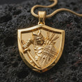 Load image into Gallery viewer, Gold plated samurai shield pendant necklace presented on porous volcanic rock, highlighting the defensive warrior motif in a luxurious close-up jewelry image.
