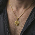 Load image into Gallery viewer, Gold plated Eye of Providence sun pendant necklace worn on the neck, captured on a human model in a premium dark-toned lifestyle frame.

