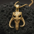 Load image into Gallery viewer, Gold plated Mythosaur skull pendant necklace presented on porous volcanic rock, highlighting the iconic warrior emblem in a luxurious close-up jewelry image.
