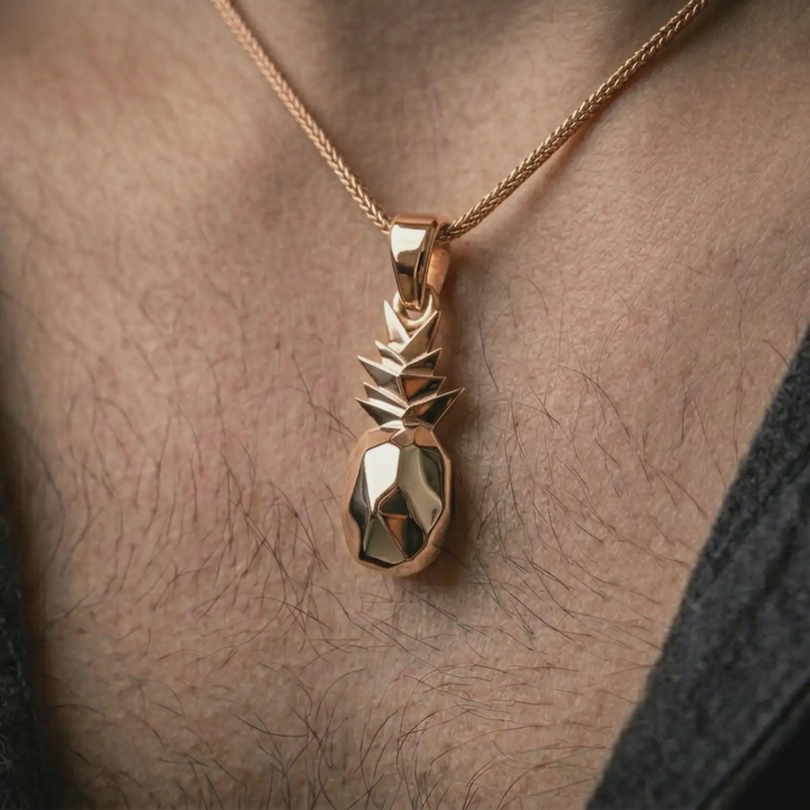 Rose gold plated origami pineapple pendant necklace worn on the neck, presented in a close-up lifestyle shot with a refined contemporary aesthetic.