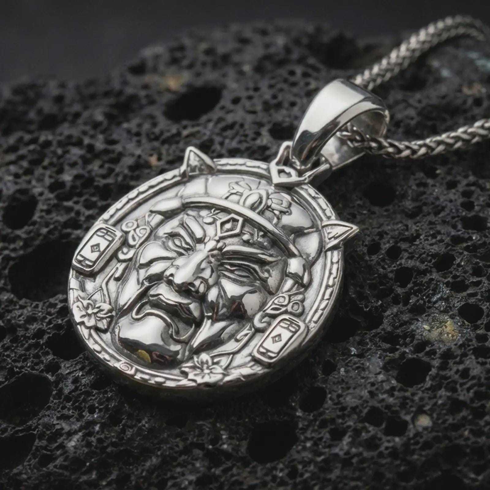 A polished 925 sterling silver Oni pendant on volcanic rock showing crisp relief details and clean shine on the raised edges.