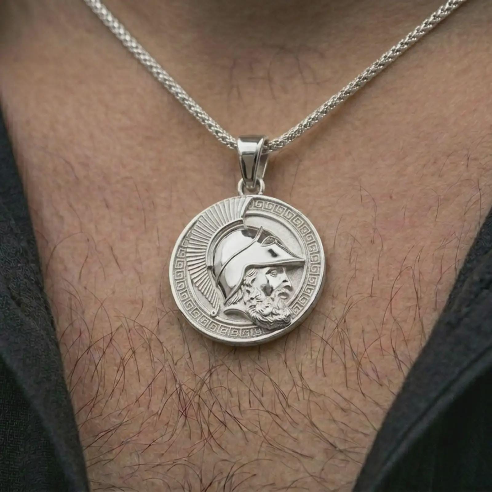 Polished silver Spartan helmet pendant necklace worn on the neck, shown against the chest in a clean and elegant everyday wear composition.