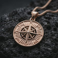 Load image into Gallery viewer, Rose gold plated compass rose pendant necklace on dark volcanic rock, photographed in a detailed premium studio macro view.
