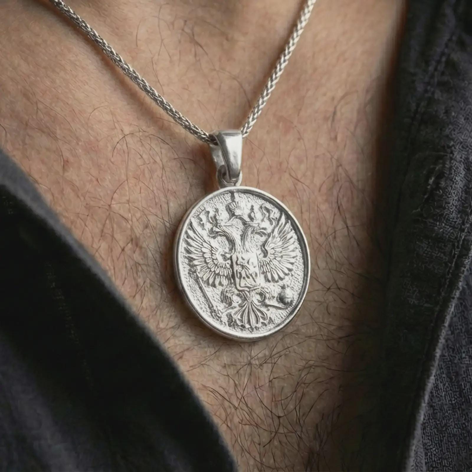 Polished silver double headed eagle pendant necklace worn on the neck, shown in a clean model shot with the round eagle crest pendant centered for a refined heritage-inspired look.