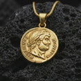Load image into Gallery viewer, Gold plated Emperor Augustus coin pendant necklace photographed on porous black volcanic stone, emphasizing the imperial bust, laurel crown, and historical Latin inscription in a luxury jewelry composition.

