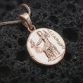 Load image into Gallery viewer, Rose gold plated Alexander the Great coin pendant necklace presented on textured volcanic stone, showcasing the engraved Greek figure, antique-inspired surface, and round historic medallion form in a macro studio shot.
