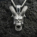 Load image into Gallery viewer, Polished silver rabbit skull pendant necklace displayed on black volcanic rock, shown in a refined macro product shot with long upright ears, open jaw, and gothic skull detail.
