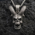 Load image into Gallery viewer, Sterling silver rabbit skull pendant necklace with an oxidized finish resting on textured volcanic rock, captured in a close-up premium studio composition.
