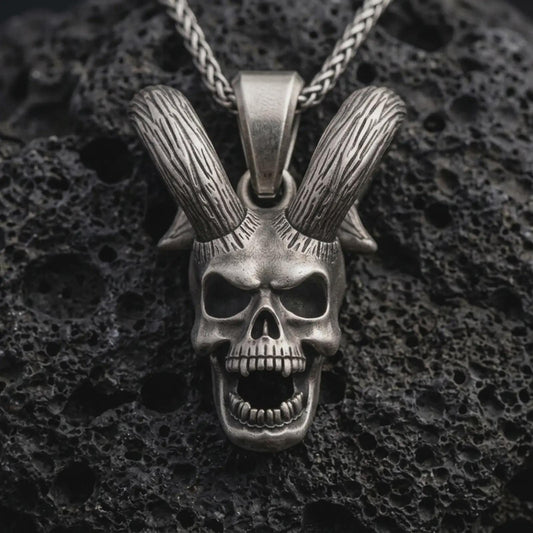 Sterling silver rabbit skull pendant necklace with an oxidized finish resting on textured volcanic rock, captured in a close-up premium studio composition.