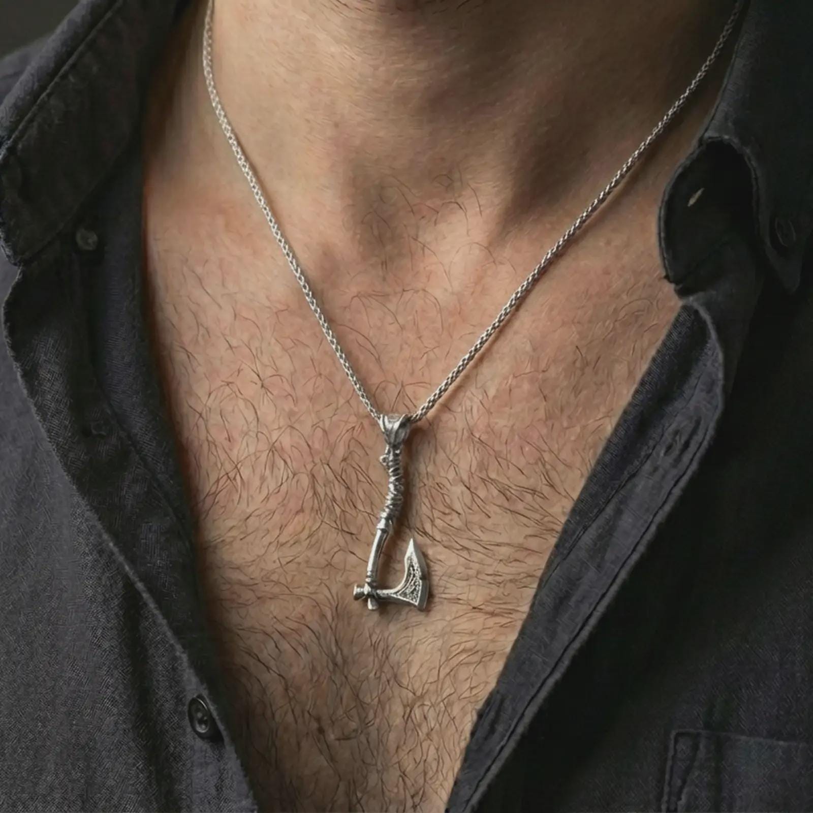 Polished silver battle axe pendant necklace worn on the neck, shown against the chest in a clean and striking everyday wear composition.