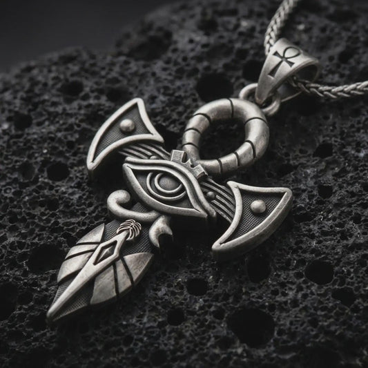 Sterling silver Eye of Horus ankh pendant necklace with an oxidized finish resting on textured volcanic rock, captured in a close-up premium studio composition.