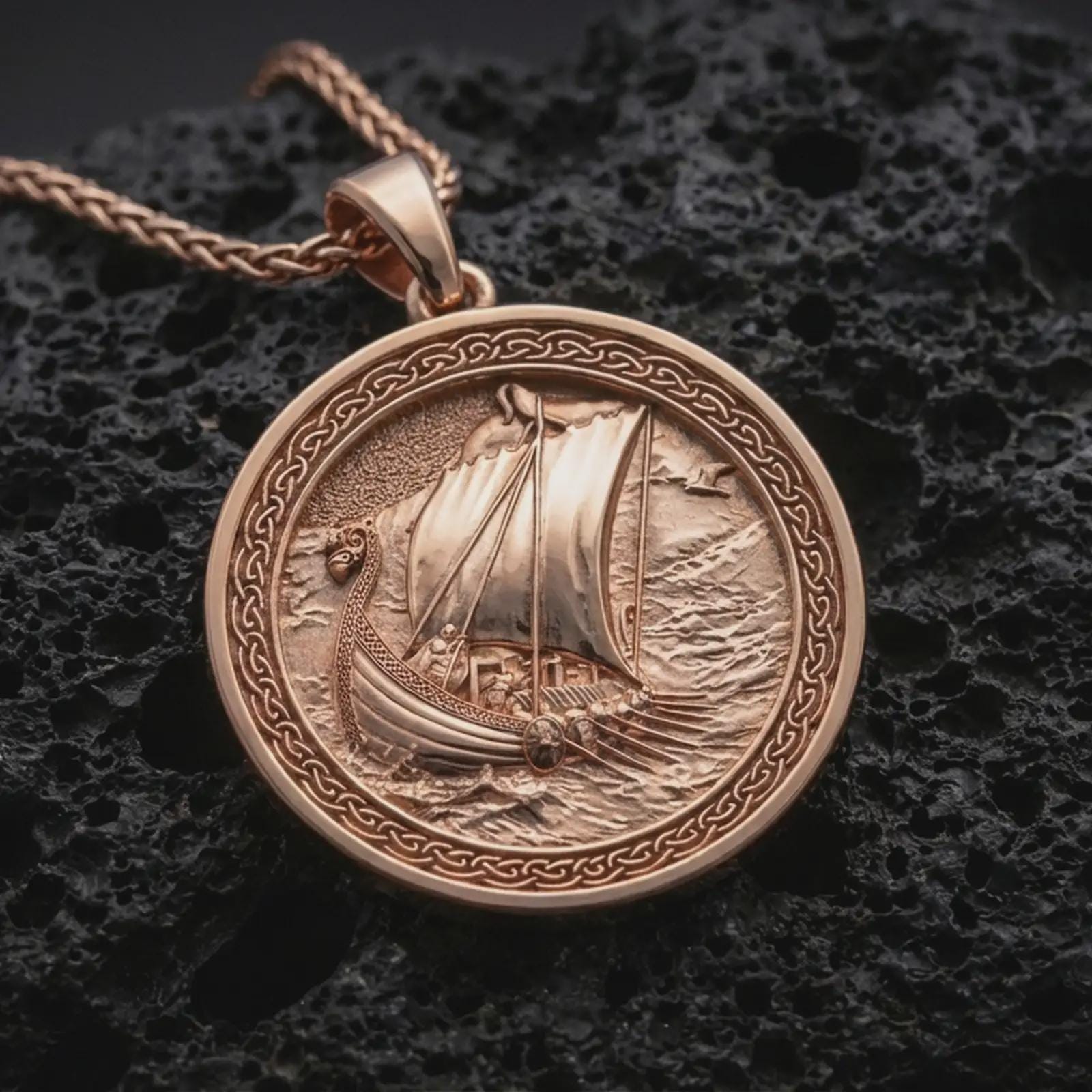 Rose gold plated Viking ship pendant necklace on dark volcanic rock, photographed in a detailed premium studio macro view.