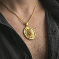 Load image into Gallery viewer, Gold plated snarling wolf pendant necklace worn on the neck, captured on a human model in a premium dark-toned lifestyle frame.
