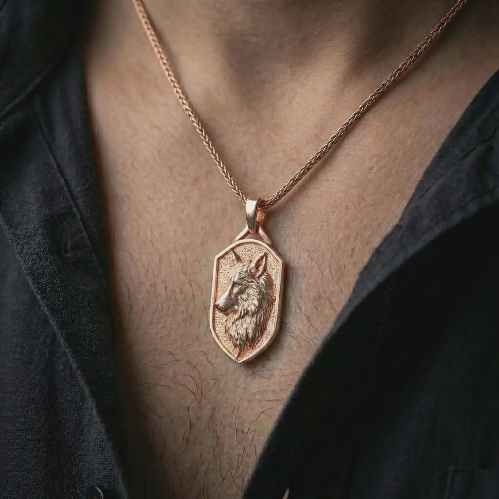 Rose gold plated wolf shield pendant necklace worn on the neck, presented in a close-up lifestyle shot with a refined wildlife-inspired aesthetic.