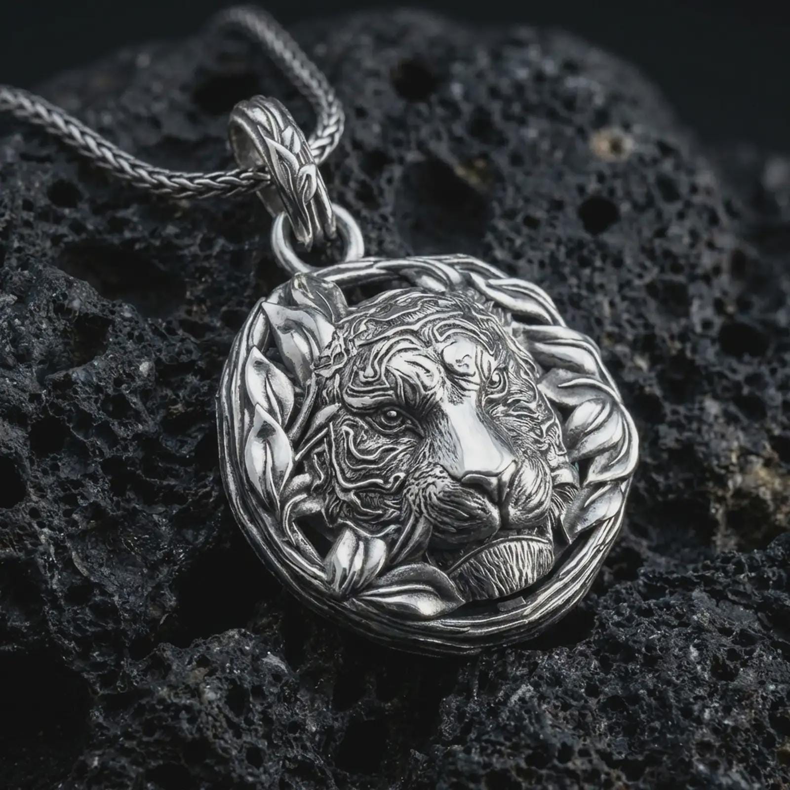 A polished 925 sterling silver tiger pendant on volcanic rock showing crisp facial relief, smooth shine, and wreath detail.