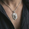 Load image into Gallery viewer, Polished silver ferocious wolf shield pendant necklace worn on the neck, shown against the chest in a clean and striking everyday wear composition.
