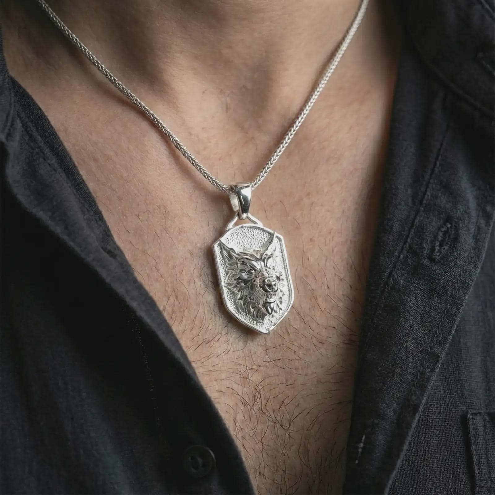 Polished silver ferocious wolf shield pendant necklace worn on the neck, shown against the chest in a clean and striking everyday wear composition.