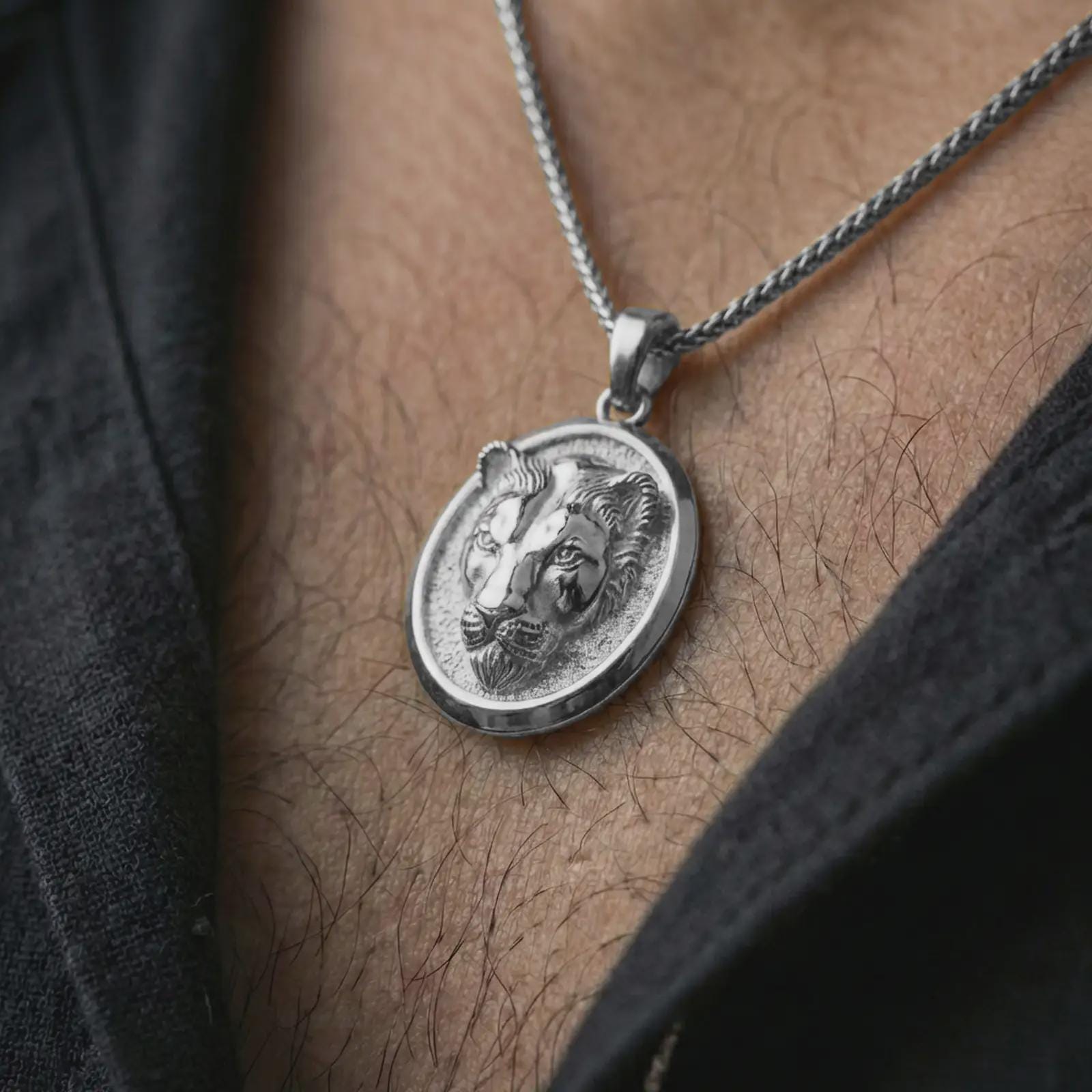 Polished silver lioness pendant necklace worn on the neck, shown against the chest in a clean and striking everyday wear composition.