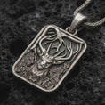 Load image into Gallery viewer, Sterling silver stag forest pendant necklace with an oxidized finish resting on textured volcanic rock, captured in a close-up premium studio composition.

