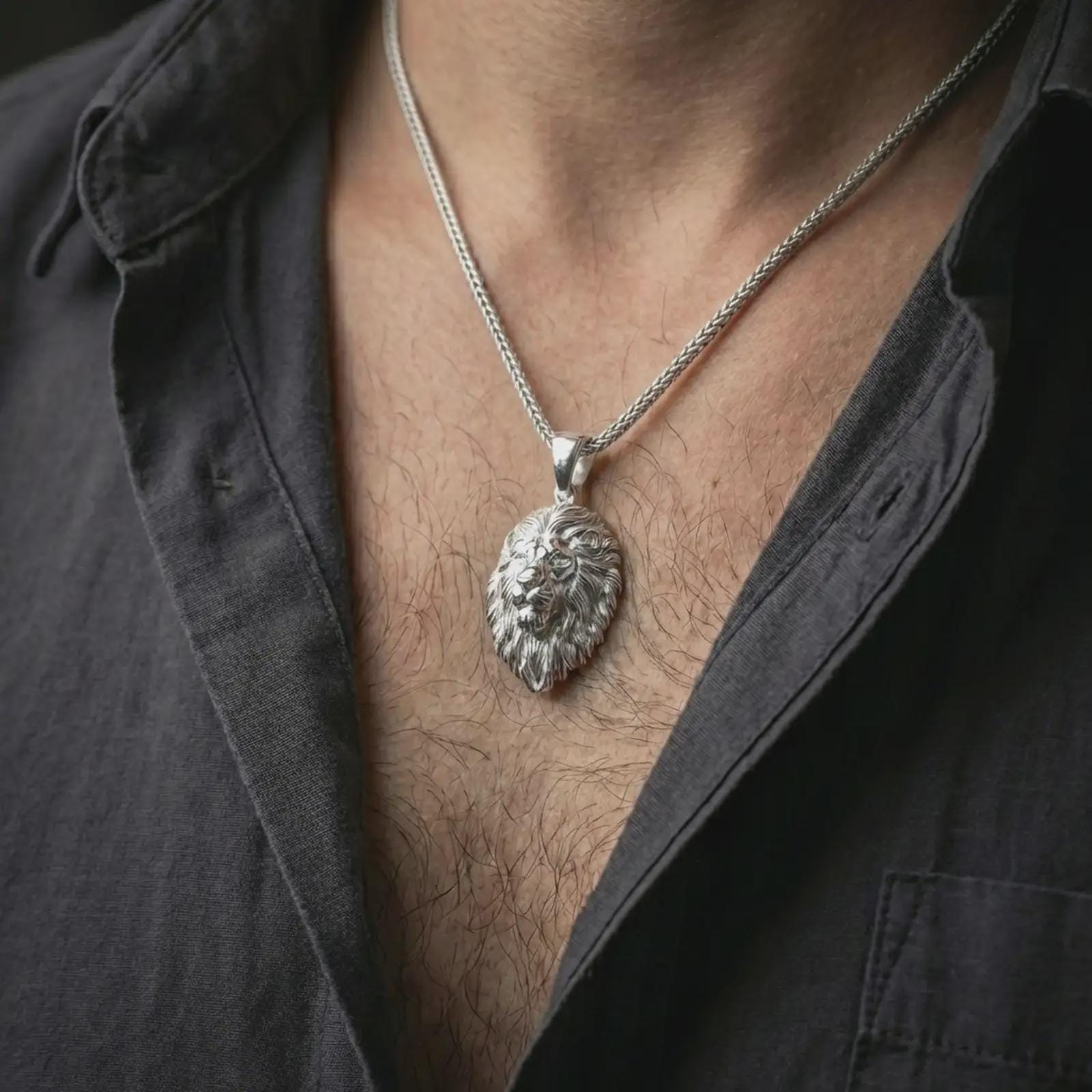 Polished silver lion head pendant necklace worn on the neck, shown against the chest in a clean and striking everyday wear composition.