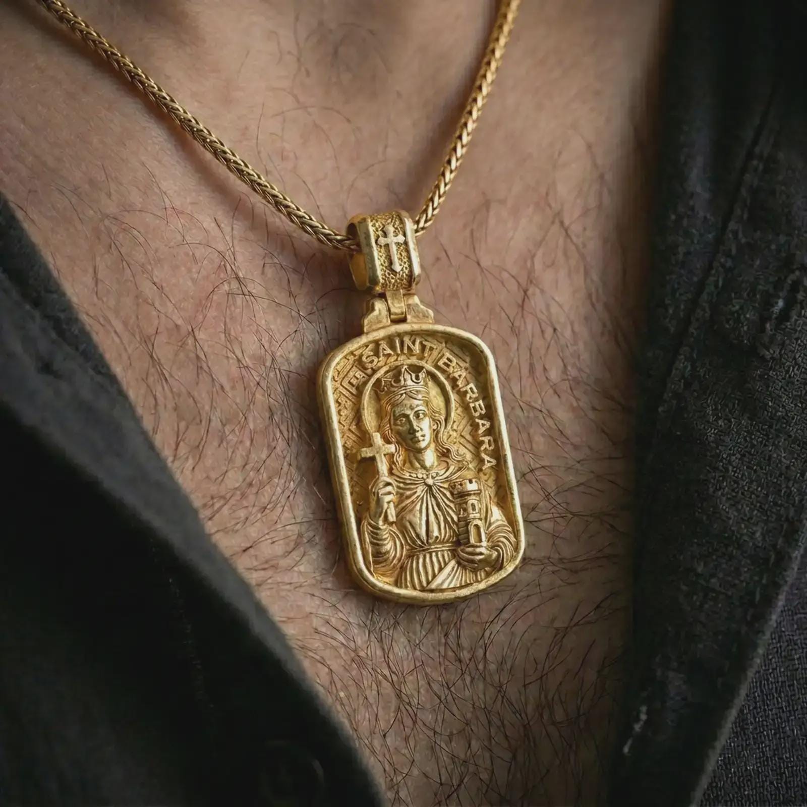 Gold plated Saint Barbara pendant necklace worn on the chest, premium lifestyle jewelry photo with the religious icon pendant centered on a spiga chain.