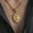Load image into Gallery viewer, Gold plated Saint Paul pendant necklace worn on the chest, premium lifestyle jewelry photo with the Catholic apostle medal centered on a spiga chain.
