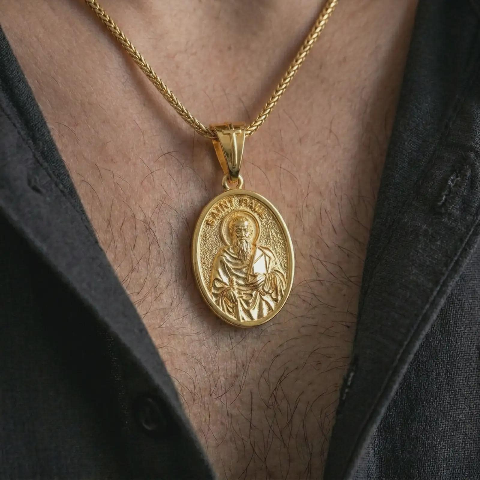 Gold plated Saint Paul pendant necklace worn on the chest, premium lifestyle jewelry photo with the Catholic apostle medal centered on a spiga chain.