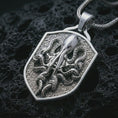 Load image into Gallery viewer, Polished silver kraken octopus shield pendant necklace displayed on black volcanic rock, shown in a refined macro product shot with curled tentacles, suction cup details, and angular shield frame.
