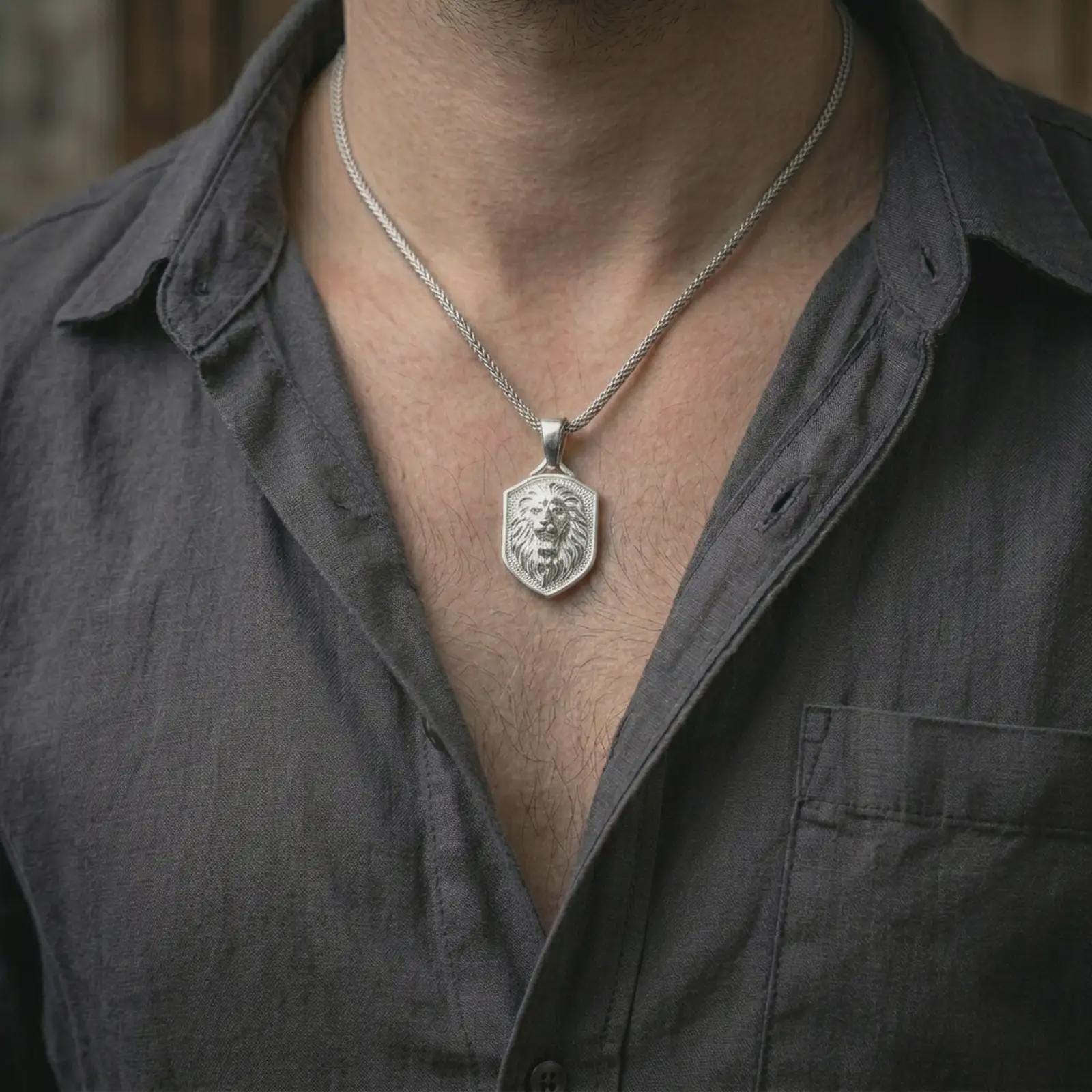 Polished silver roaring lion shield pendant necklace worn on the neck, shown against the chest in a clean and striking everyday wear composition.