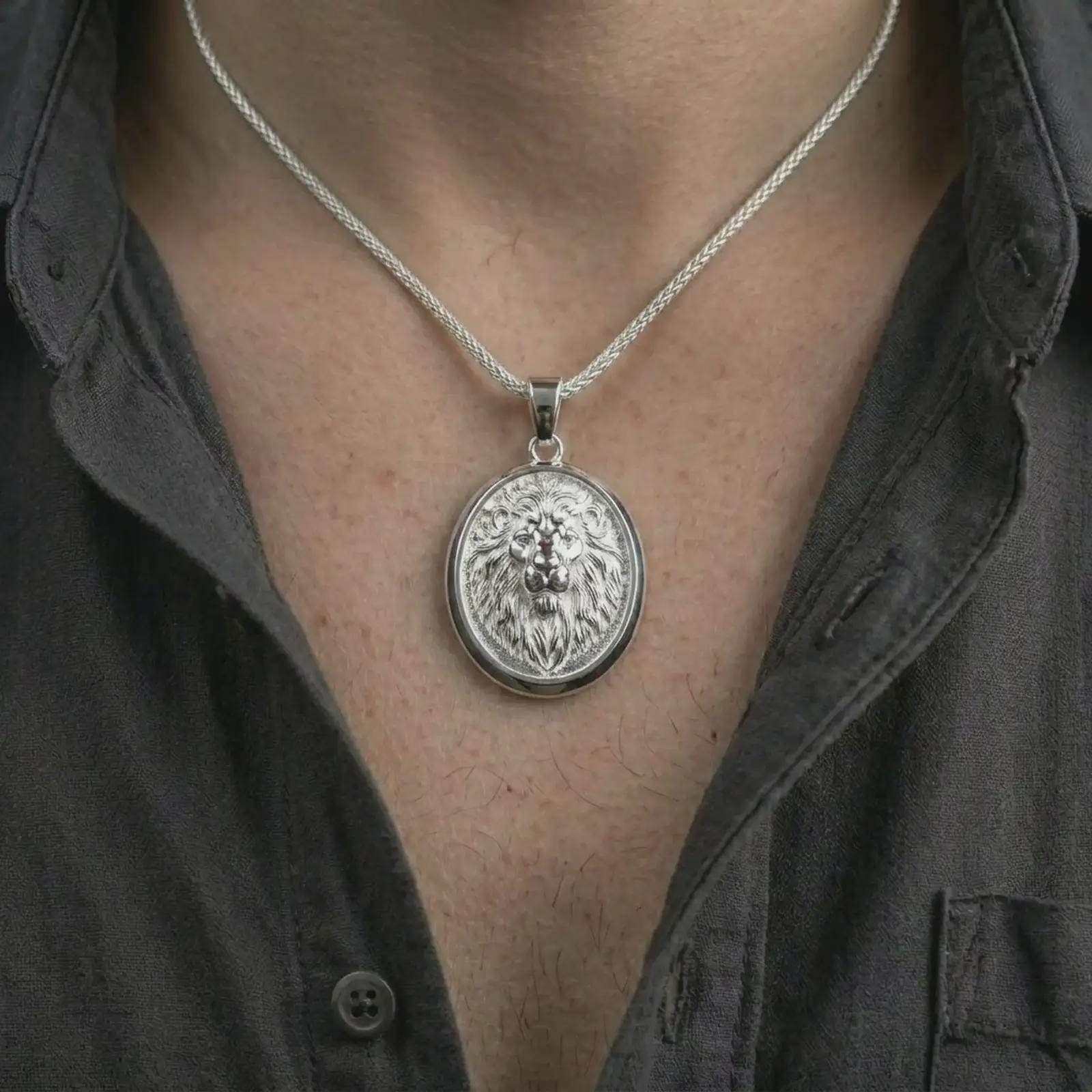 Polished silver lion medallion pendant necklace worn on the neck, shown against the chest in a clean and striking everyday wear composition.