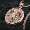 Load image into Gallery viewer, Rose gold plated ram head pendant necklace on dark volcanic rock, photographed in a detailed premium studio macro view.
