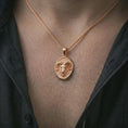 Load image into Gallery viewer, Rose gold plated ram head pendant necklace worn on the neck, presented in a close-up lifestyle shot with a refined mythic aesthetic.
