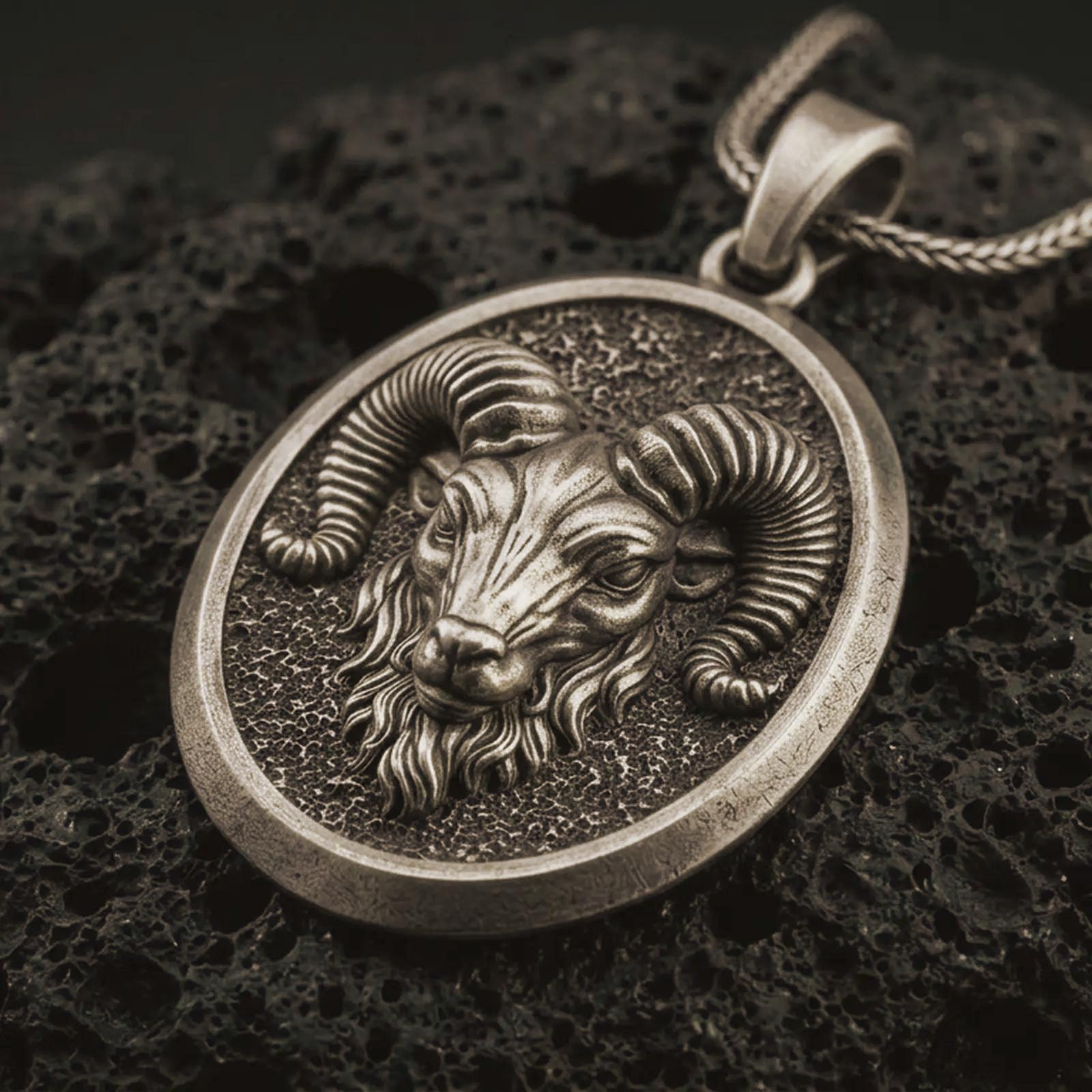 Bronze ram head pendant necklace with an oxidized finish resting on textured volcanic rock, captured in a close-up premium studio composition.