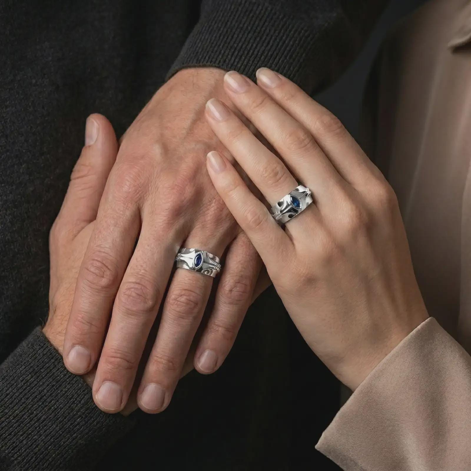 A sterling silver ring with a polished silver finish and marquise blue stone worn on a finger in a clean lifestyle close-up.