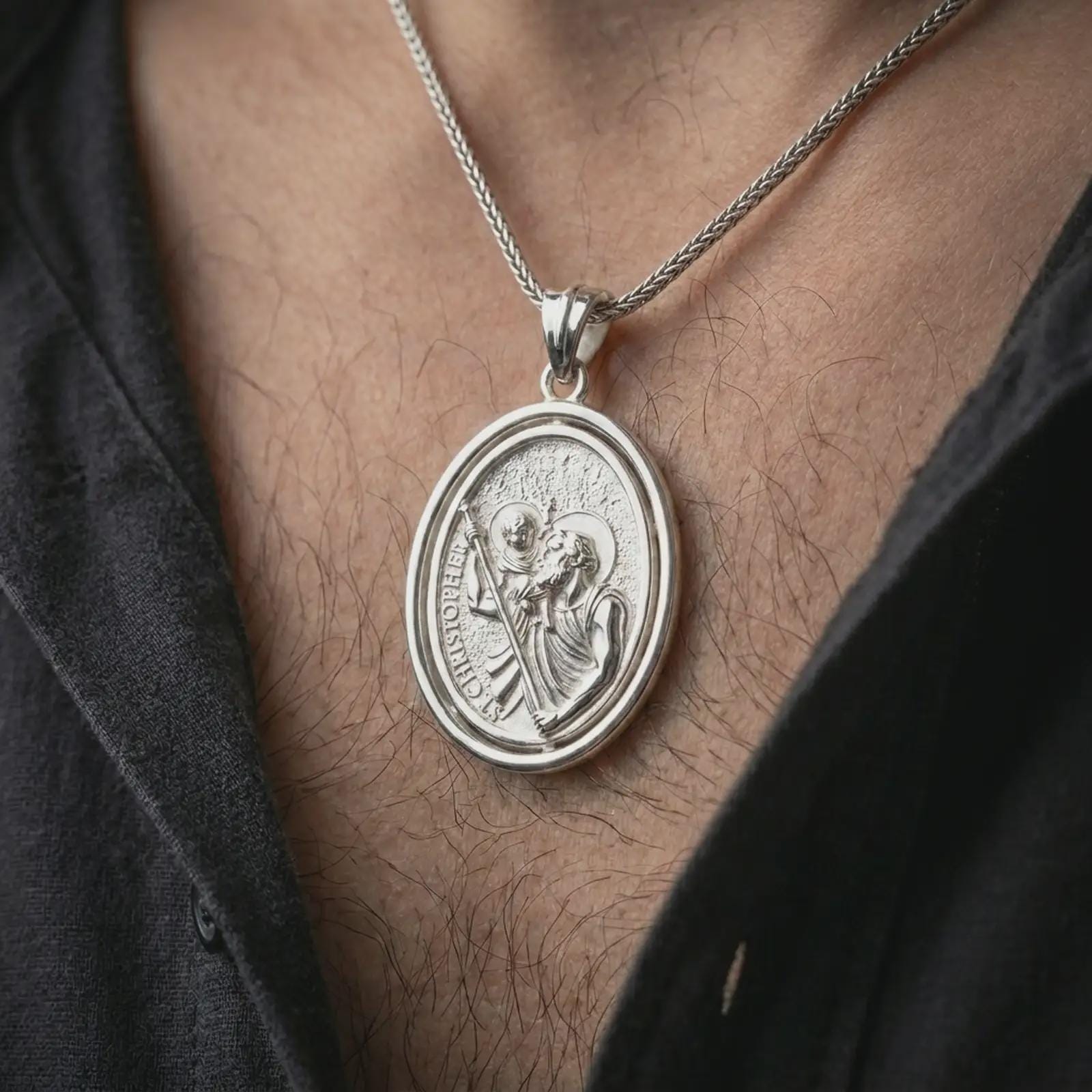 Polished silver Saint Christopher spinning pendant necklace worn on the chest, masculine lifestyle shot highlighting the saint carrying child Jesus, staff detail, and bright silver finish.