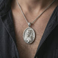 Load image into Gallery viewer, Polished silver Jesus Christ Good Shepherd pendant necklace worn on the chest, masculine lifestyle shot highlighting the shepherd portrait, robe detail, and bright silver finish.
