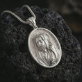 Load image into Gallery viewer, Polished silver Jesus Christ Good Shepherd pendant necklace on textured volcanic rock, centered macro jewelry photo with detailed Christian relief and bright silver highlights.
