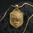 Load image into Gallery viewer, Gold plated roaring lion shield pendant necklace presented on porous volcanic rock, highlighting the warrior-inspired lion motif in a luxurious close-up jewelry image.
