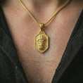 Load image into Gallery viewer, Gold plated gorilla shield pendant necklace worn on the neck, captured on a human model in a premium dark-toned lifestyle frame.
