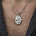 Load image into Gallery viewer, Polished silver wolf medallion pendant necklace worn on the neck, shown against the chest in a clean and striking everyday wear composition.
