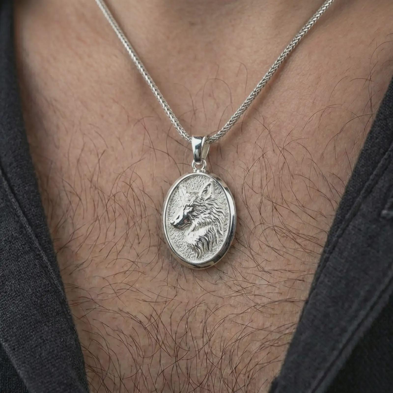 Polished silver wolf medallion pendant necklace worn on the neck, shown against the chest in a clean and striking everyday wear composition.
