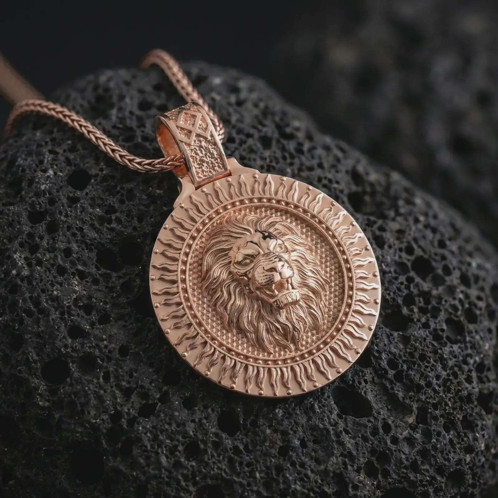 Rose gold plated Viking lion medallion pendant necklace on dark volcanic rock, photographed in a detailed premium studio macro view.