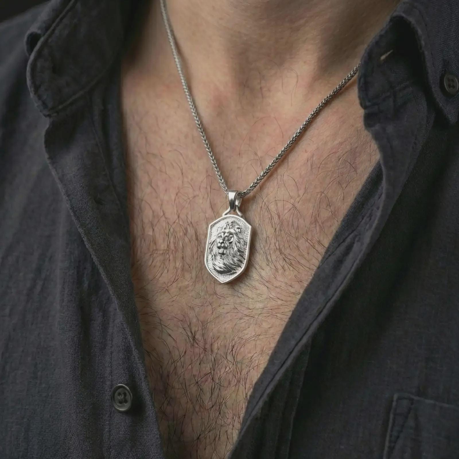 Polished silver lion shield pendant necklace worn on the neck, shown against the chest in a clean and striking everyday wear composition.
