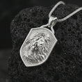 Load image into Gallery viewer, Polished silver lion shield pendant necklace displayed on black volcanic rock, shown in a refined macro product shot with windswept mane detail, regal facial sculpting, and angular shield frame.
