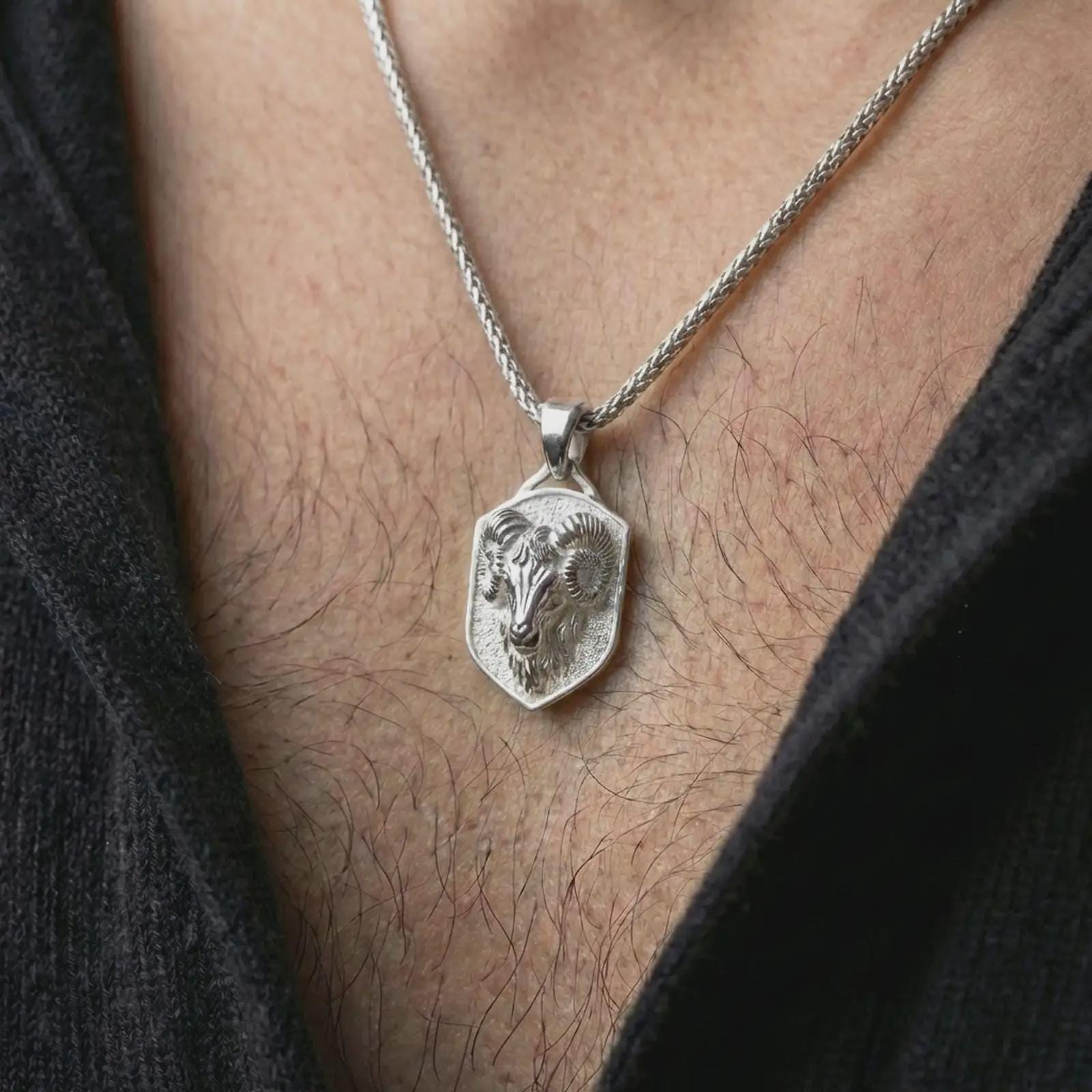 Polished silver ram head shield pendant necklace worn on the neck, shown against the chest in a clean and striking everyday wear composition.