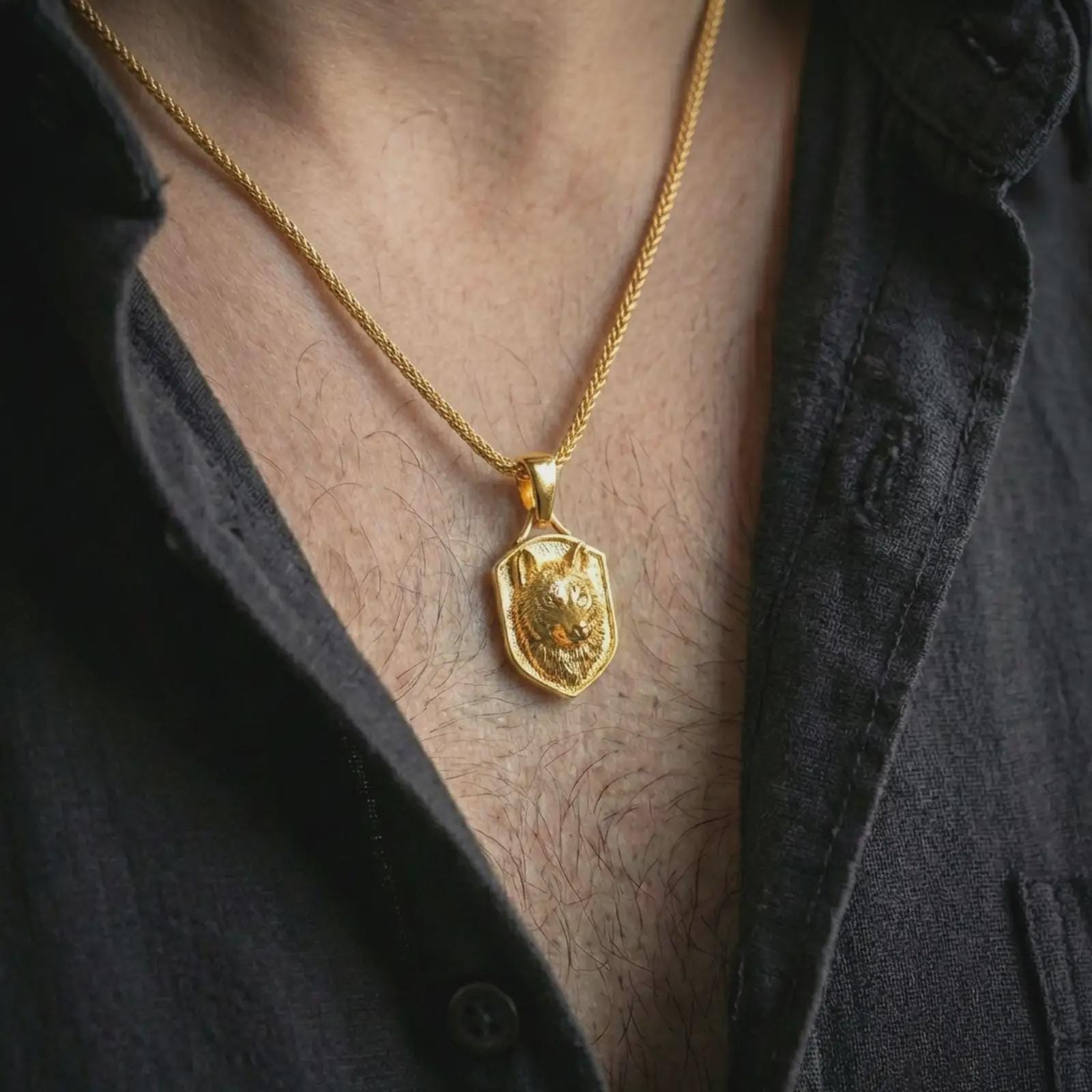 Wolf shield pendant necklace with a gold plated finish worn on the neck, captured in a premium lifestyle composition with the pendant centered on the chest.
